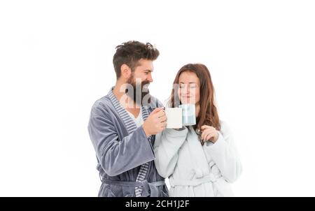 Profiter de la compagnie de l'autre. Parfait matin de couple d'amour. Un couple heureux dans des peignoirs avec café. Une jeune fille romantique heureuse prenant le petit déjeuner avec son mari. Couple des moments de vie à la maison. Banque D'Images