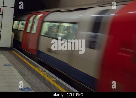 Train souterrain de Londres vu entrer dans la plate-forme de la gare à pleine vitesse. Banque D'Images