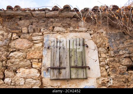 Fenêtre avec volets en bois fermés sur une ancienne maison en pierre traditionnelle abandonnée à Dalmatie, Croatie Banque D'Images