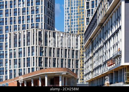 Construction active et façades de nouveaux immeubles d'appartements dans un quartier résidentiel de la ville bloc le fond du ciel bleu. Banque D'Images