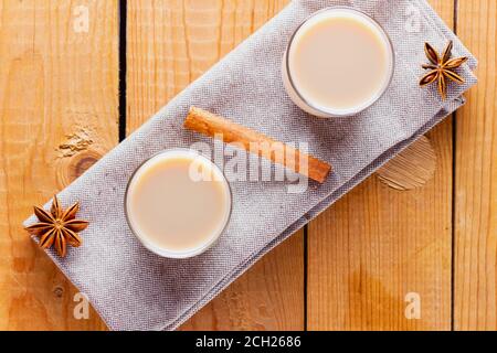 Thé aux herbes avec lait et épices. Thé indien Masala Chai fait maison sur des planches en bois. Boisson d'automne dans des tasses de thé turc Banque D'Images