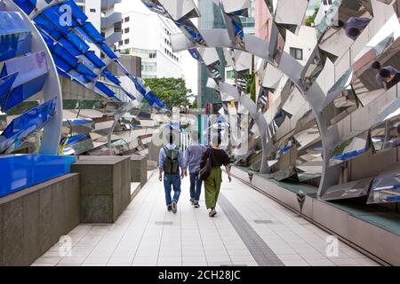 Shibuya, Tokyo / Japon - juin 2018 : trois jeunes Japonais marchent dans un tunnel unique qui sort d'un grand centre commercial. Banque D'Images