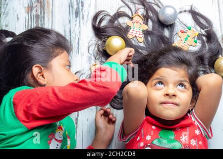 Father décorant leurs cheveux avec des décorations de Noël Banque D'Images