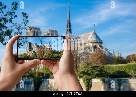 Touriste prenant une photo de la vue latérale de notre Dame de Paris ou de la Cathédrale notre-Dame lors de la restauration à Paris, France Banque D'Images