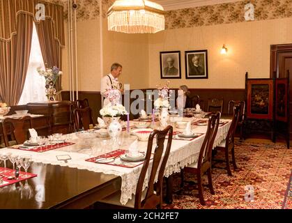 Les acteurs jouent le rôle de Henriette Forget, épouse du lieutenant-gouverneur Amedee Forget et de son cuisinier, M. Phillips, dans l'une des nombreuses vignettes historiques qui ont été mises en place en 1905 à Government House à Regina, en Saskatchewan, Canada.la maison a été utilisée comme résidence officielle des lieutenants-gouverneurs des Territoires du Nord-Ouest et, plus tard, de la Saskatchewan jusqu'en 1945. Les meubles et les vêtements sont choisis pour représenter le temps du lieutenant-gouverneur Amedee Forget (1898-1910). La mainlevée de propriété n'est pas nécessaire parce que ce musée appartient au gouvernement canadien et est ouvert gratuitement au public. Banque D'Images