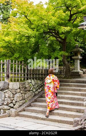 Arashiyama, Kyoto / Japon - 21 juin 2018 : une belle femme japonaise dans un kimono traditionnel monte les marches d'un jardin de temple bouddhiste. Banque D'Images