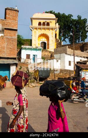 Chitrakoot, Madhya Pradesh, Inde : les femmes marchent dans la rue en portant leurs bagages sur la tête. Banque D'Images