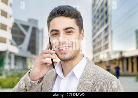 Joyeux jeune homme d'affaires réussi à vous regarder avec un sourire crasseux Banque D'Images