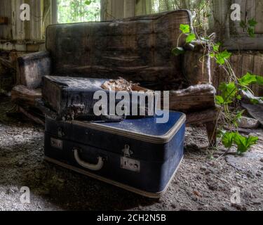 maison abandonnée avec canapés et valises Banque D'Images