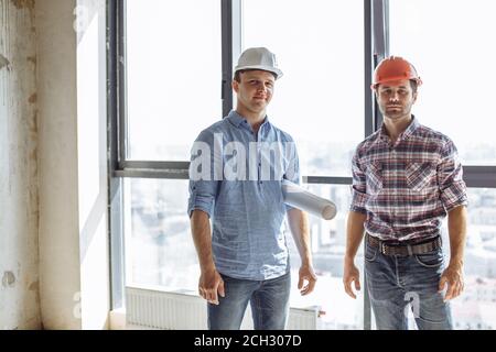 Portrait de deux travailleurs talentueux confiants debout dans la zone de construction. Équipe, concept de coopération Banque D'Images