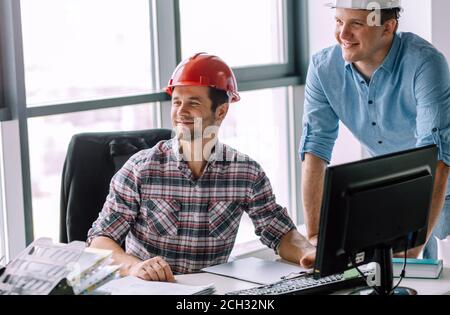 les constructeurs optimistes de vêtements décontractés dans la salle de bureau moderne. concept de travail préféré Banque D'Images