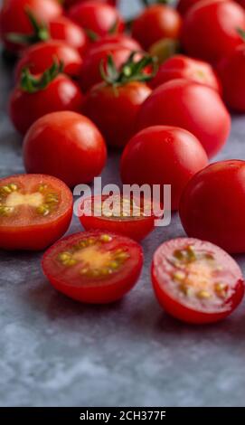 Tomates cerises avec un peu de fruits coupés Banque D'Images