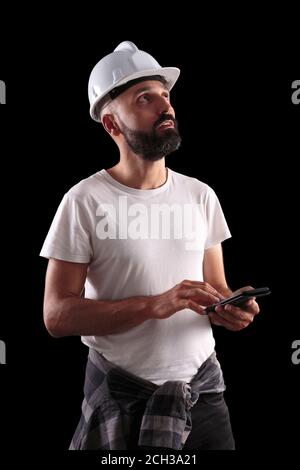 Un jeune ouvrier du bâtiment qualifié fait quelques calculs Banque D'Images