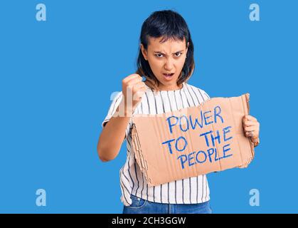 Une jeune femme qui tient le pouvoir sur la bannière du peuple a énervé et frustré criant avec colère, hurlant fou avec colère et la main levée Banque D'Images