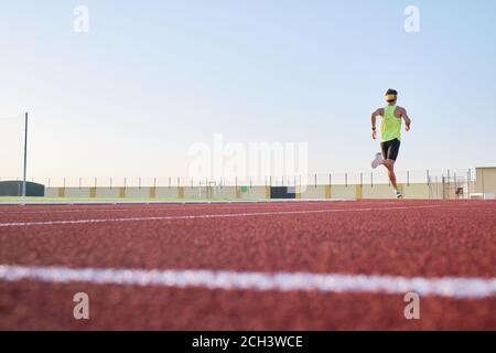 les jeunes hommes s'entraîne sur des pistes neuves et rouges Banque D'Images