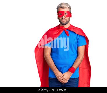 Jeune homme blond portant super héros crème sceptique et nerveux, frowning bouleversé à cause du problème. Personne négative. Banque D'Images