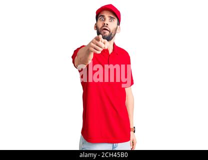 Jeune homme beau avec la barbe portant l'uniforme de livraison pointant mécontent et frustré à l'appareil photo, en colère et furieux avec vous Banque D'Images