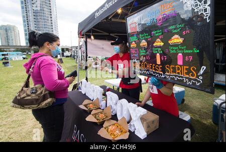 Toronto, Canada. 13 septembre 2020. Une femme (L) portant un masque achète de la nourriture au festival Mac and Cheese de 2020 à Toronto, Canada, le 13 septembre 2020. Organisé par Street Eats Market, le festival a eu lieu ici du samedi au dimanche dans le cadre de la pandémie COVID-19. Credit: Zou Zheng/Xinhua/Alamy Live News Banque D'Images