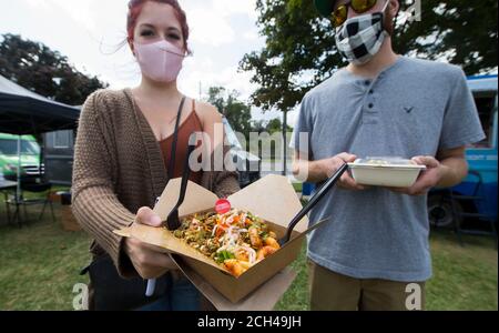 Toronto, Canada. 13 septembre 2020. Une femme portant un masque facial montre sa nourriture au festival Mac and Cheese de 2020 à Toronto, Canada, le 13 septembre 2020. Organisé par Street Eats Market, le festival a eu lieu ici du samedi au dimanche dans le cadre de la pandémie COVID-19. Credit: Zou Zheng/Xinhua/Alamy Live News Banque D'Images