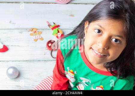 Cute brunette girl with Christmas pyjama smiling Banque D'Images