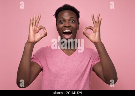 Portrait d'un homme afro-américain heureux montrant le signe ok et sourire Banque D'Images