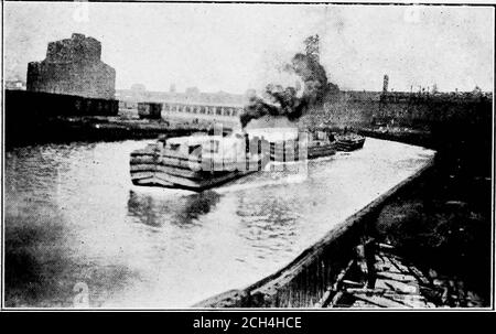 . Le problème des transports américains ; une étude des conditions de transport américaines, en vue de déterminer quelle politique les Américains devraient adopter afin de répondre efficacement aux conditions existantes et être prêts à continuer à diriger les nations dans la marche du progrès et de la civilisation . PONT ÉLÉVATEUR DE HALSTEAD STREET, CHICAGO RIVER. 23 septembre 1908.Tug J. C. Evans et Steamer Tiogo, appartenant à Erie Railroad COM-pany. Ce pont est étroit, la rivière est sur une courbe inverse, et est contourné un endroit difficile à traverser, surtout quand il y a un currentvers le canal de drainage. C'est le cas Banque D'Images