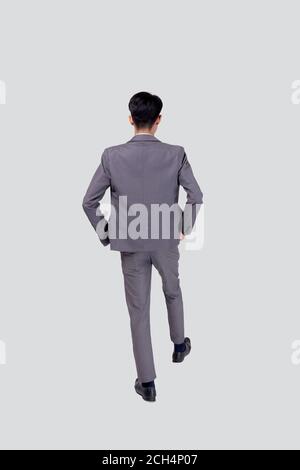 Vue arrière jeune homme d'affaires asiatique en costume à pied isolé sur fond blanc, portrait de cadre ou de directeur, homme d'affaires heureux beau et smar Banque D'Images