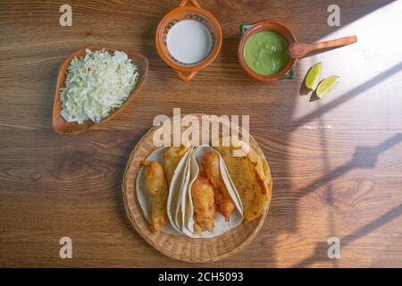 Vue de dessus de tacos de poisson de style Basse-Californie avec guacamole, crème et chou. Cuisine mexicaine Banque D'Images