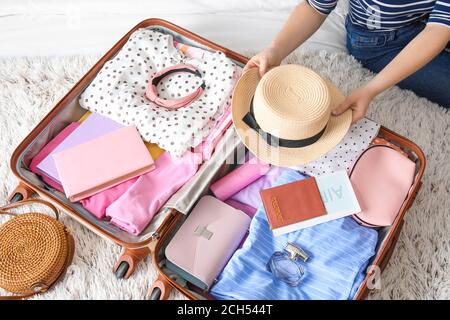 Femme emballant sa valise pour un voyage à la maison Banque D'Images