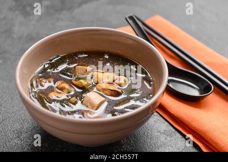 Bol avec une délicieuse soupe d'algues sur fond sombre Banque D'Images