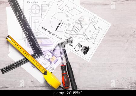Ruban de mesure avec fournitures de construction et bleus sur fond en bois Banque D'Images