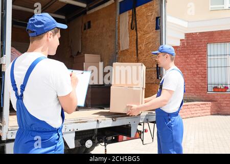 Chargeurs prenant le fret du camion Banque D'Images