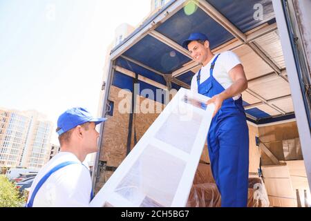 Chargeurs qui prennent les meubles des camions Banque D'Images