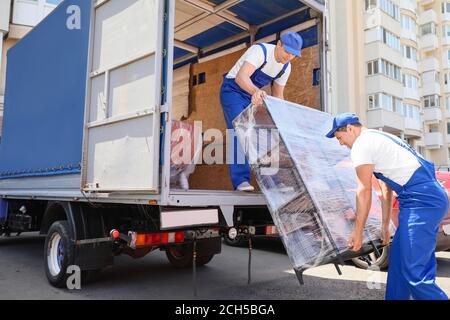 Chargeurs qui prennent les meubles des camions Banque D'Images