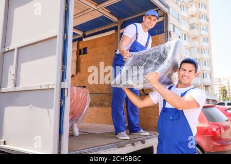 Chargeurs qui prennent les meubles des camions Banque D'Images