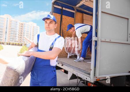 Chargeurs qui prennent les meubles des camions Banque D'Images