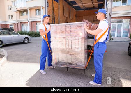 Chargeurs qui prennent les meubles des camions Banque D'Images