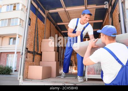 Chargeurs qui prennent les meubles des camions Banque D'Images