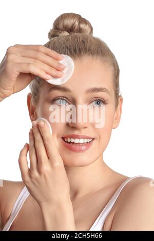 Belle jeune femme avec des tampons de coton sur fond blanc Banque D'Images