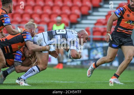 Gareth Ellis (29) de Hull FC est abordé par Oliver Holmes (11) de Castleford Tigers Banque D'Images