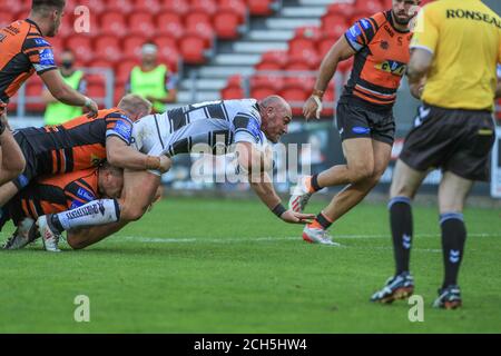 Gareth Ellis (29) de Hull FC est abordé par Oliver Holmes (11) de Castleford Tigers Banque D'Images