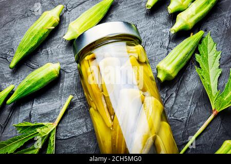 Gousses d'okra en conserve dans un pot en verre. Légumes salés marinés faits maison. Banque D'Images