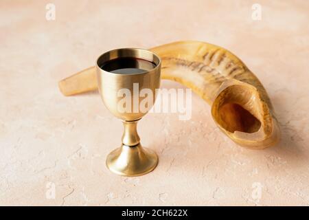 Goblet sacramentel et shofar avec vin sur fond de couleur. Rosh Hashanah (nouvel an juif) Banque D'Images