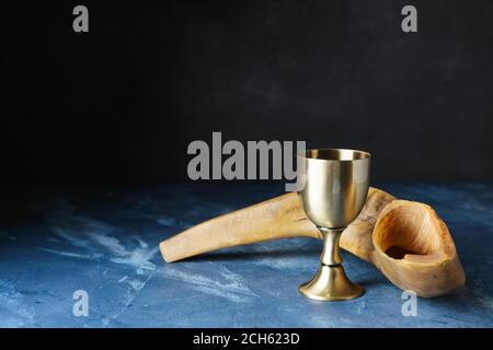 Goblet sacramentel et shofar avec vin sur fond sombre. Rosh Hashanah (nouvel an juif) Banque D'Images