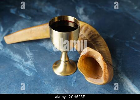 Goblet sacramentel et shofar avec vin sur fond de couleur. Rosh Hashanah (nouvel an juif) Banque D'Images