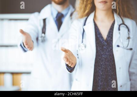 Deux médecins debout et offrant une main d'aide pour secouer la main ou sauver la vie. Aide médicale, lutte contre l'infection virale et le concept de médecine Banque D'Images