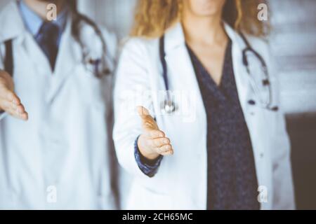 Deux médecins debout et offrant une main d'aide pour secouer la main ou sauver la vie. Aide médicale, lutte contre l'infection virale et le concept de médecine Banque D'Images