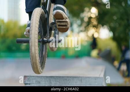 BMX dans le parc public de Moscou. Un jeune motard courageux qui fait des cascades. Il fait le tour du vélo en été. Les sports extrêmes sont très populaires chez les jeunes. Arrière / rea Banque D'Images