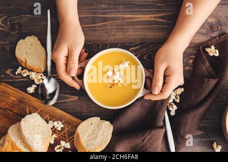 Femme avec une délicieuse soupe de pop-corn dans une casserole Banque D'Images