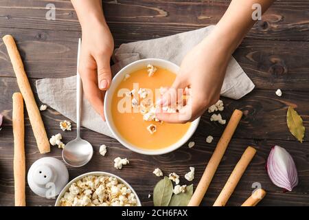 Femme avec une délicieuse soupe de pop-corn dans un bol Banque D'Images